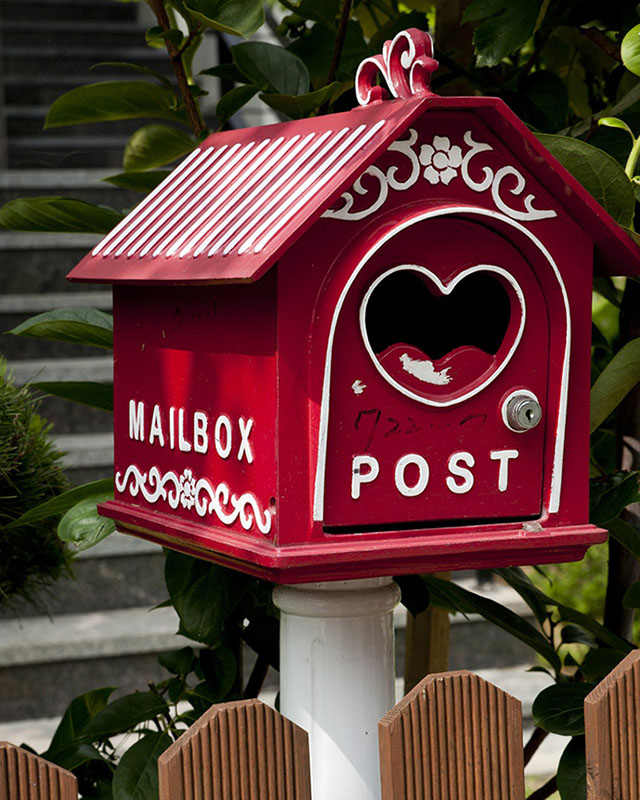 Фотография почтового ящика в виде домика с отверстием в форме сердечка.